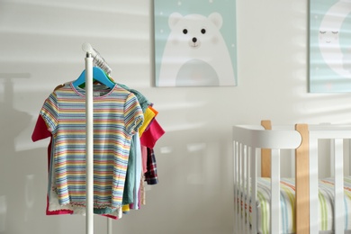 Different clothes hanging on rack in bedroom