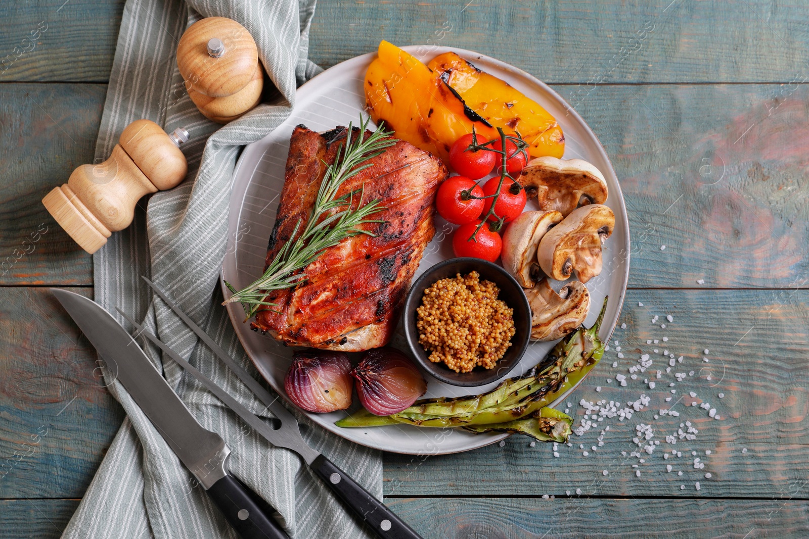 Photo of Delicious grilled meat and vegetables served on wooden table, flat lay