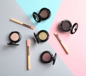 Photo of Flat lay composition with different eye shadows on color background