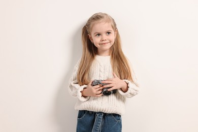 Photo of Fashion concept. Stylish girl with vintage camera on white background