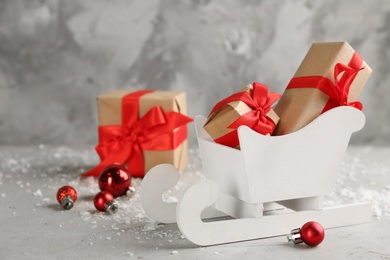Photo of Beautiful Christmas composition with miniature sleigh on light table