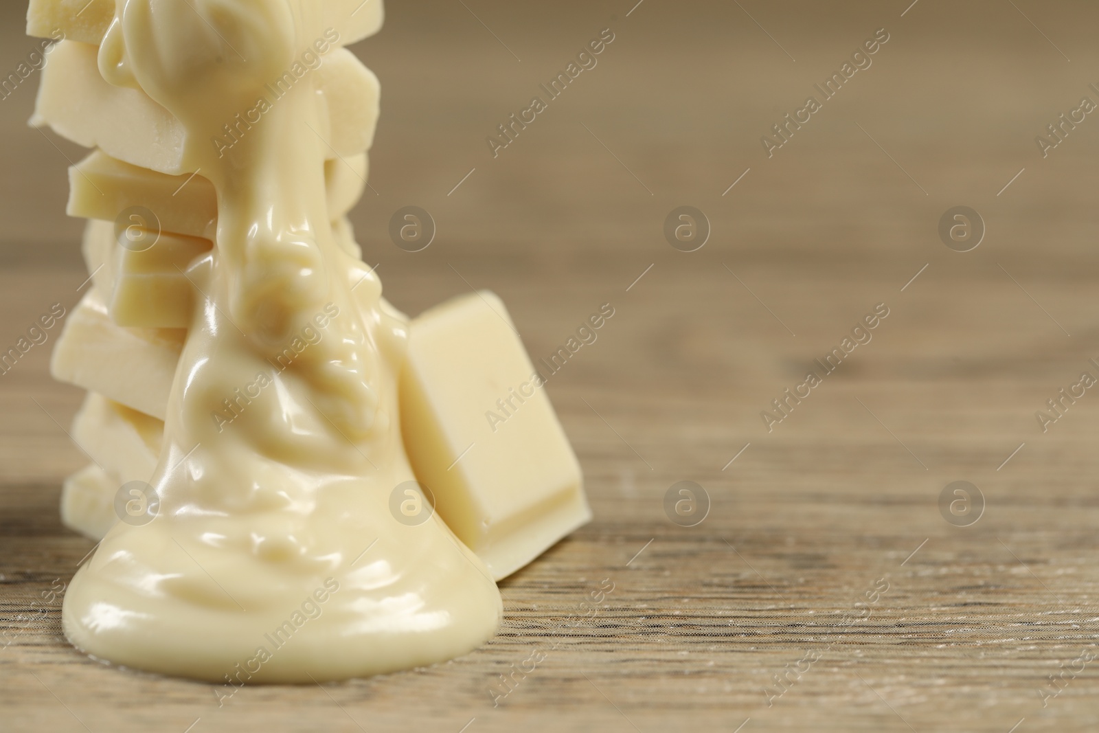 Photo of Pieces of white chocolate and tasty paste on wooden table, closeup. Space for text