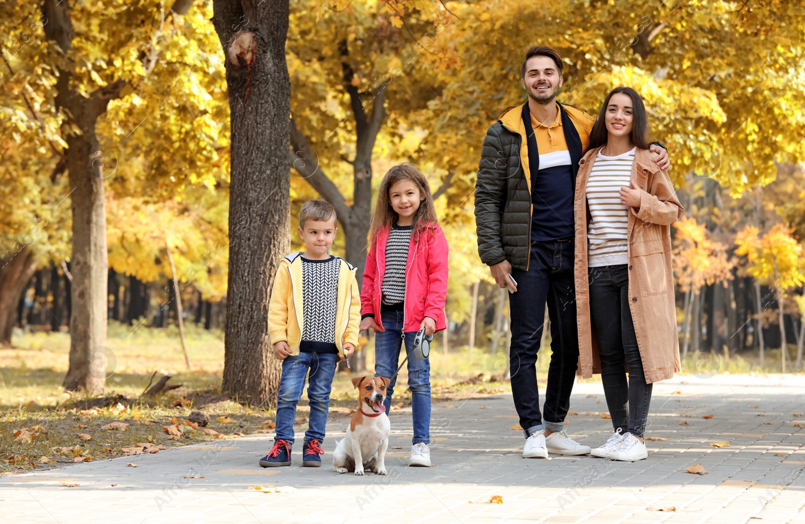 Photo of Happy family with children and dog in park. Autumn walk