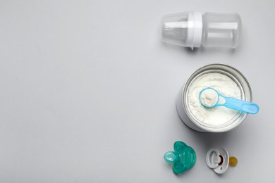 Photo of Flat lay composition with powdered infant formula on light background, space for text. Baby milk