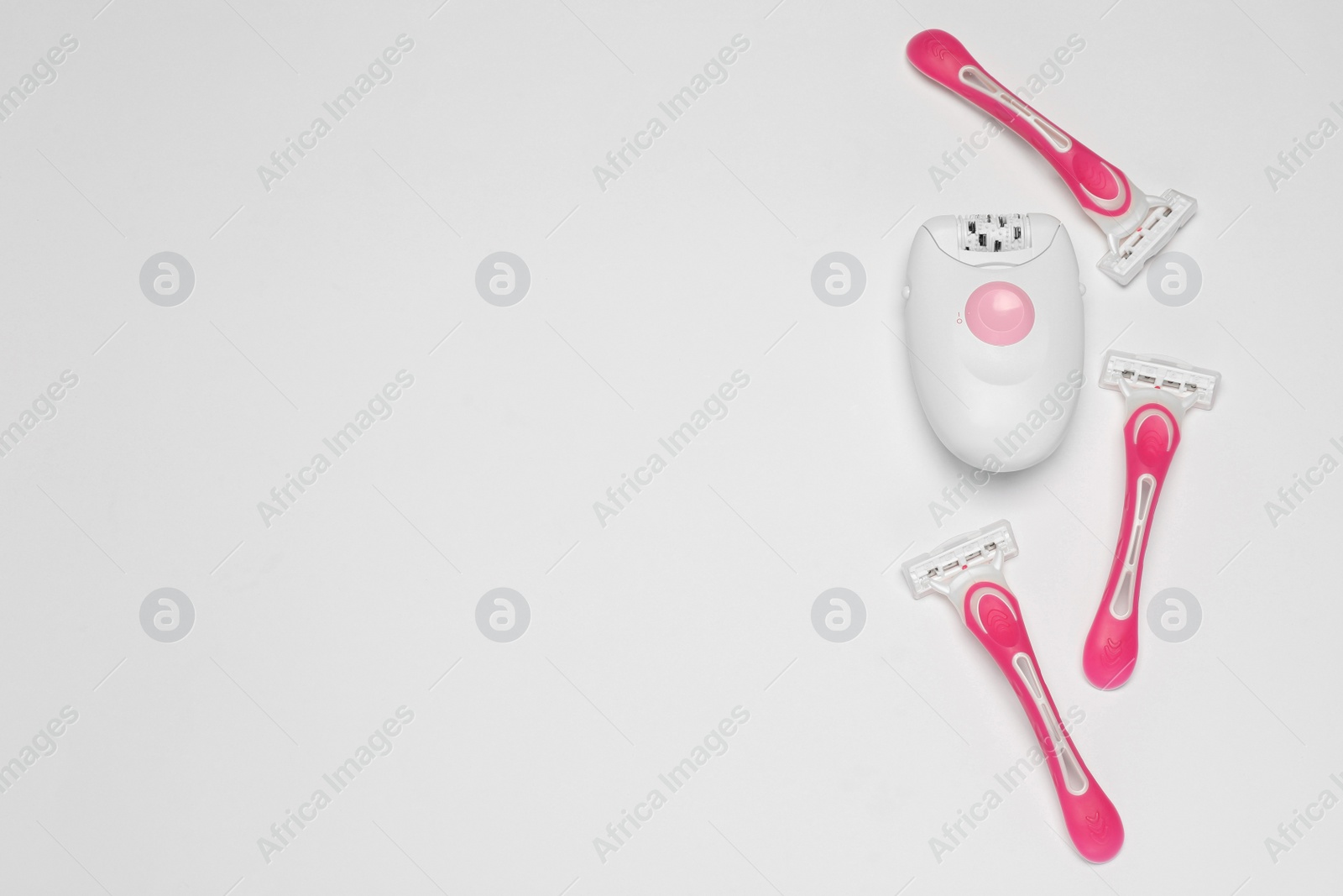 Photo of Modern epilator and razors on white background, flat lay. Space for text