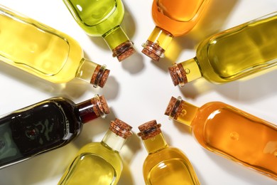 Vegetable fats. Different cooking oils in glass bottles on white background, flat lay