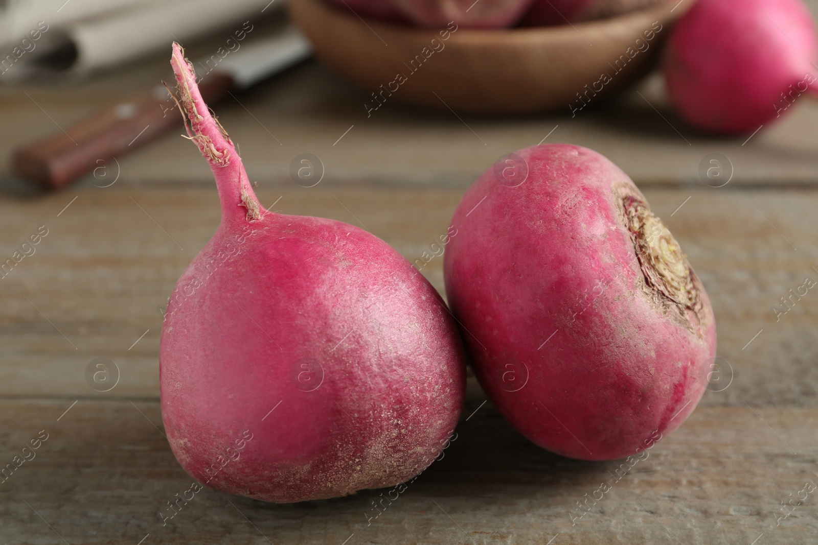 Photo of Ripe red turnips on wooden table, closeup