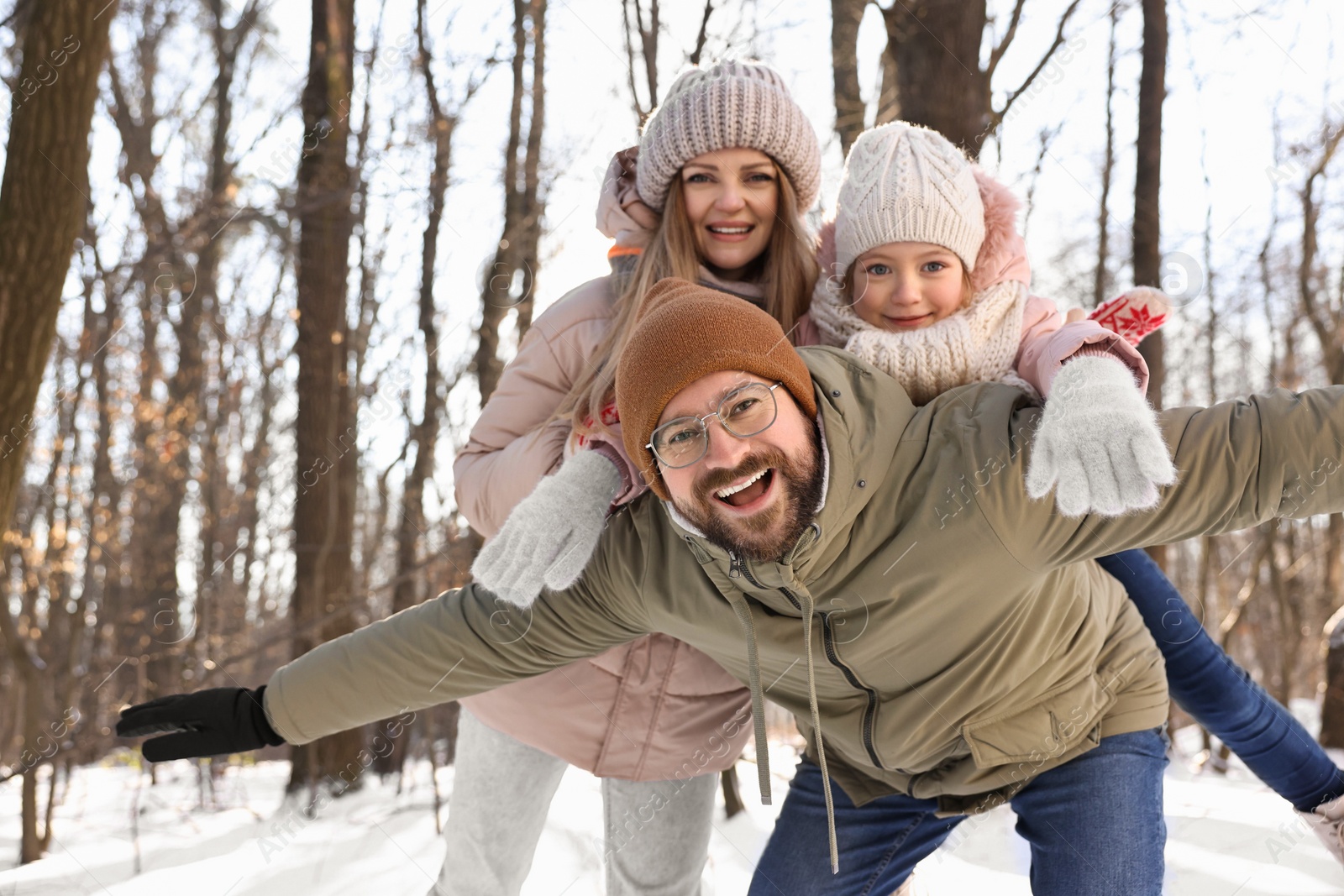 Photo of Happy family spending time together in snowy forest. Space for text