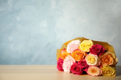 Luxury bouquet of fresh roses on wooden table. Space for text