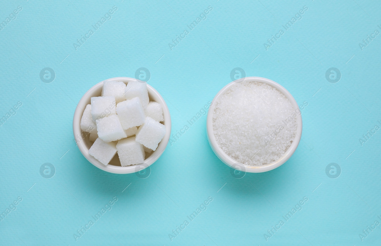 Photo of Bowls with different types of white sugar on turquoise background, flat lay