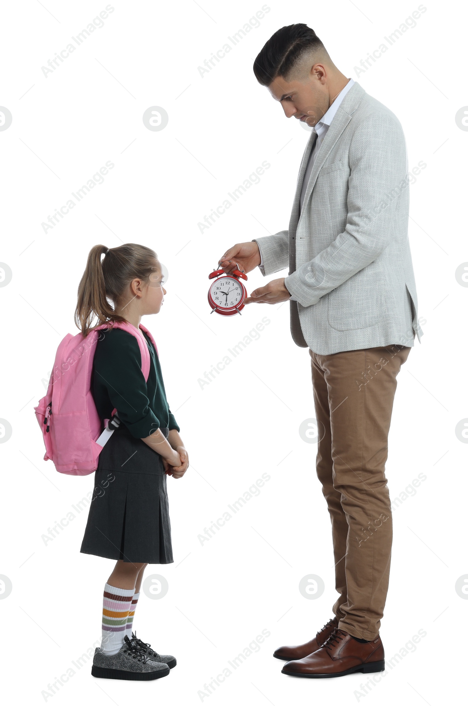 Photo of Teacher with alarm clock scolding pupil for being late against white background