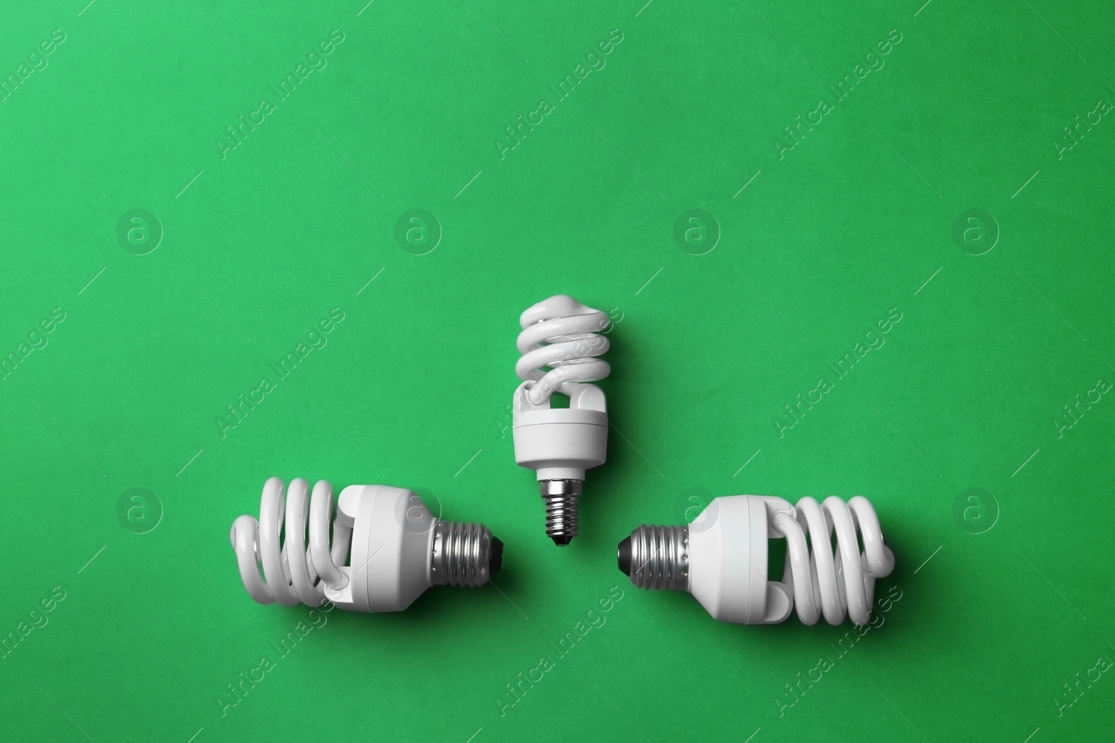 Photo of New fluorescent lamp bulbs on green background, top view