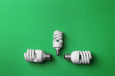 New fluorescent lamp bulbs on green background, top view