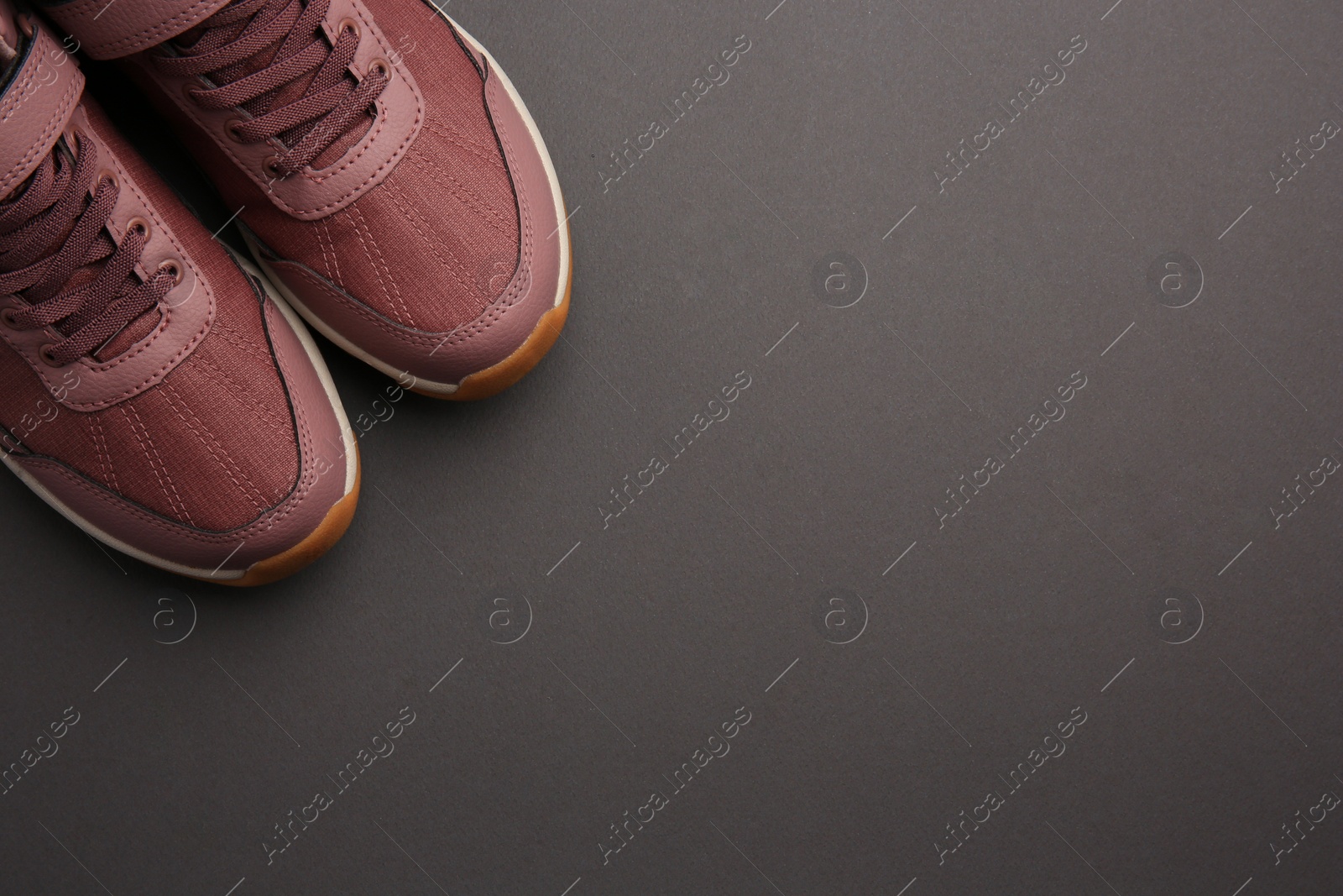 Photo of Pair of stylish kid's sneakers on black background, top view. Space for text