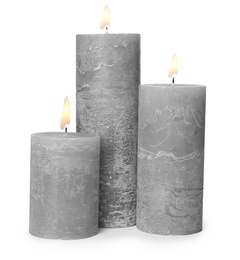 Three alight wax candles on white background