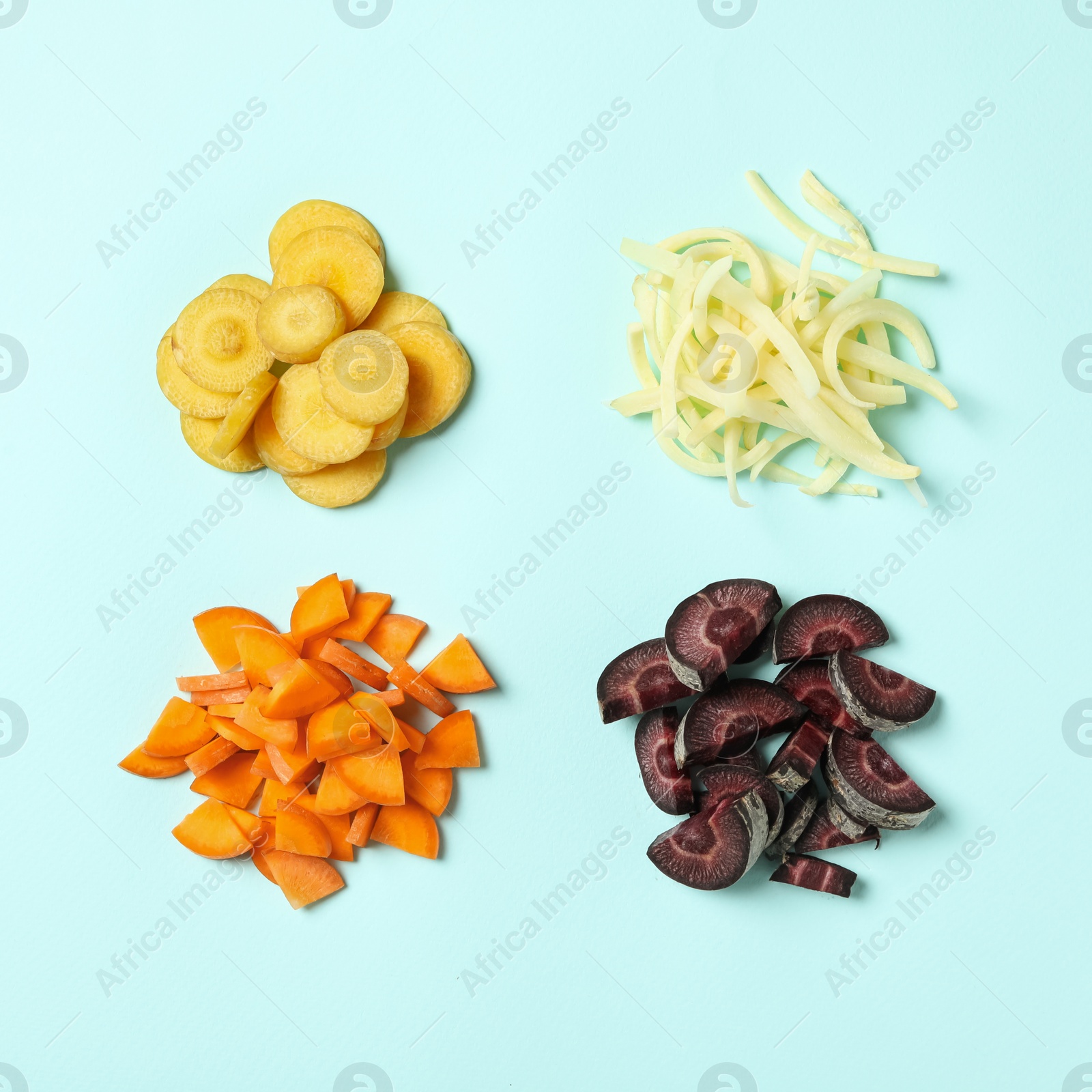 Photo of Cut raw color carrots on light blue background, flat lay