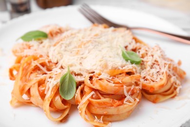 Photo of Delicious pasta with tomato sauce, chicken and parmesan cheese in plate, closeup