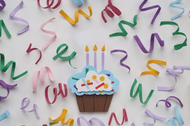 Photo of Birthday party. Paper cupcake and confetti on white background, flat lay