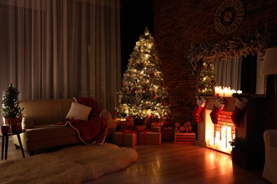 Photo of Stylish room interior with beautiful Christmas tree in evening