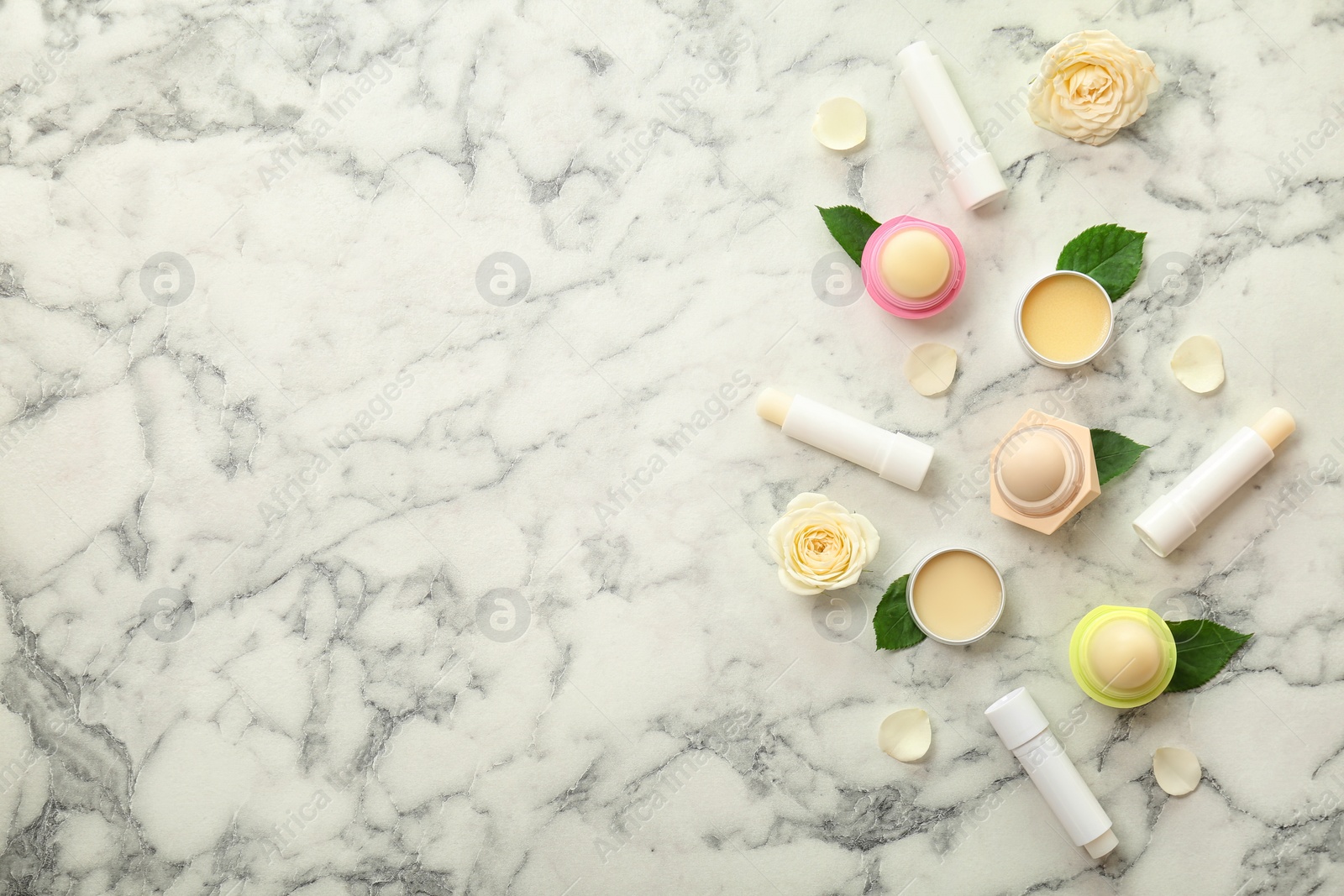 Photo of Flat lay composition with hygienic lipsticks and balms on light background