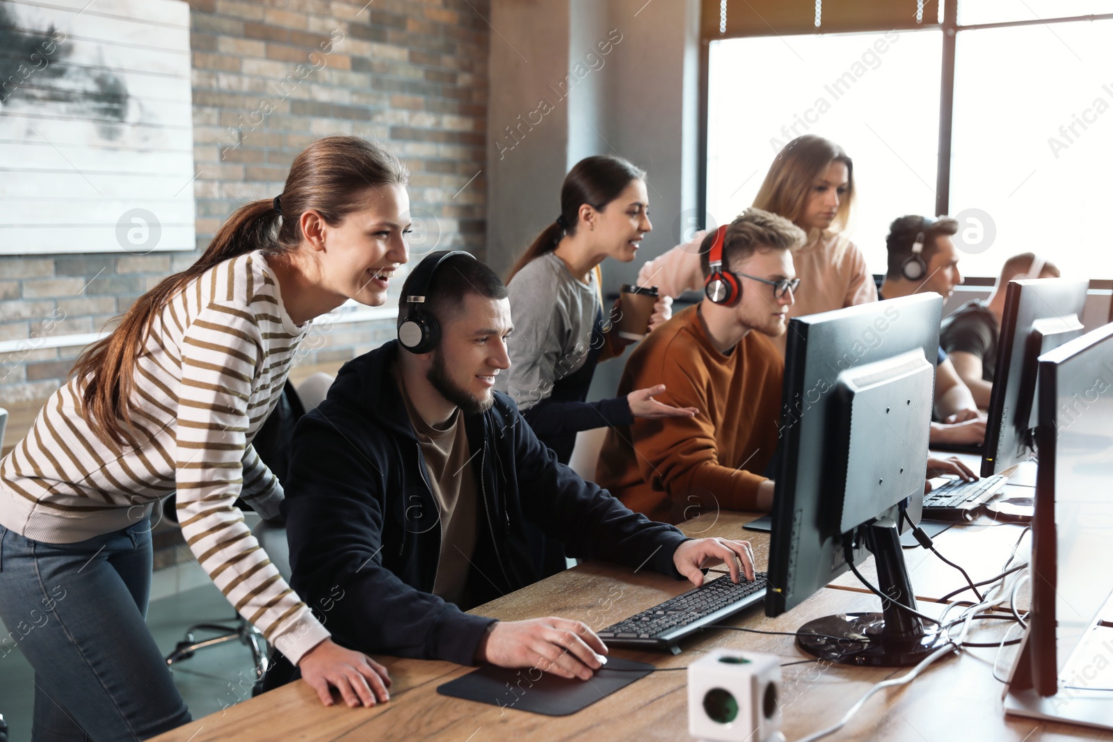 Photo of Group of people playing video games in internet cafe