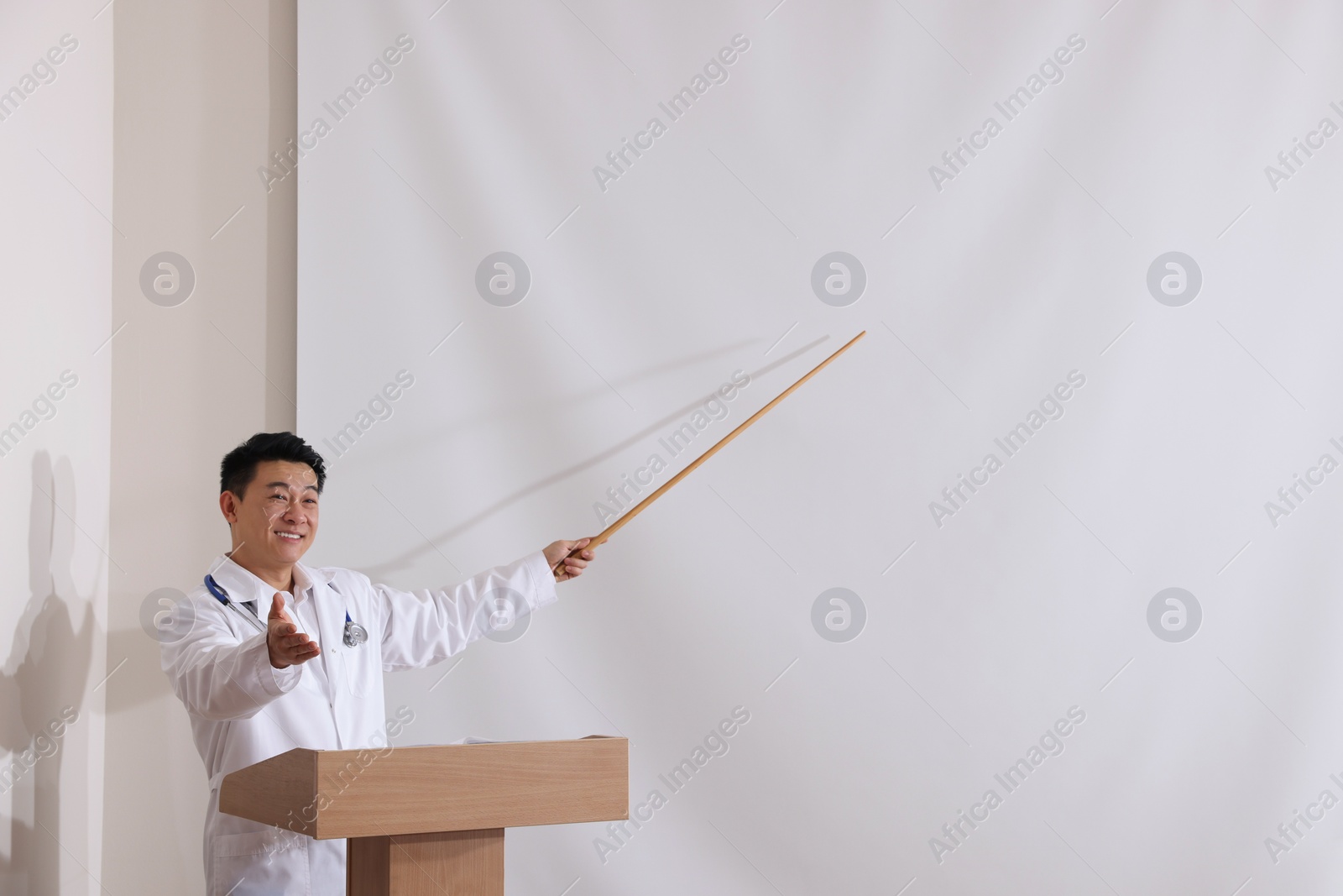 Photo of Doctor giving lecture in conference room with projection screen