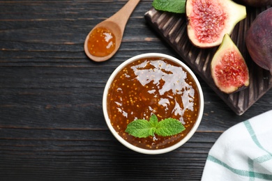 Flat lay composition with homemade delicious fig jam on black wooden table