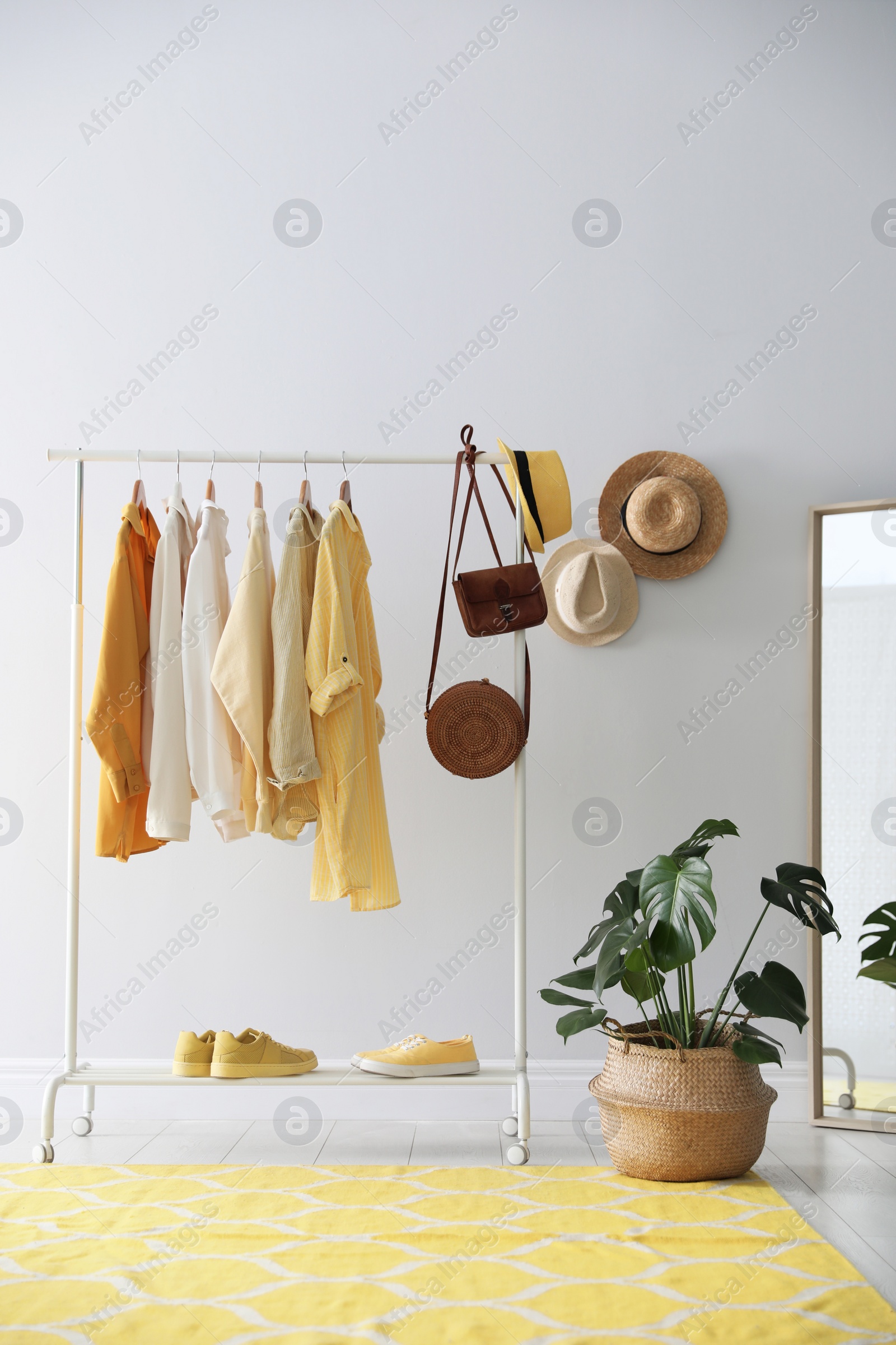 Photo of Rack with stylish women's clothes indoors. Interior design