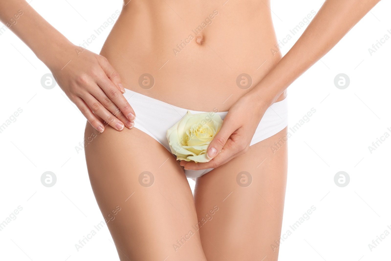 Photo of Woman with flower showing smooth skin after bikini epilation on white background, closeup. Body care concept