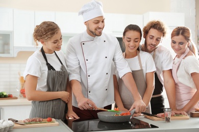 Group of people and male chef at cooking classes