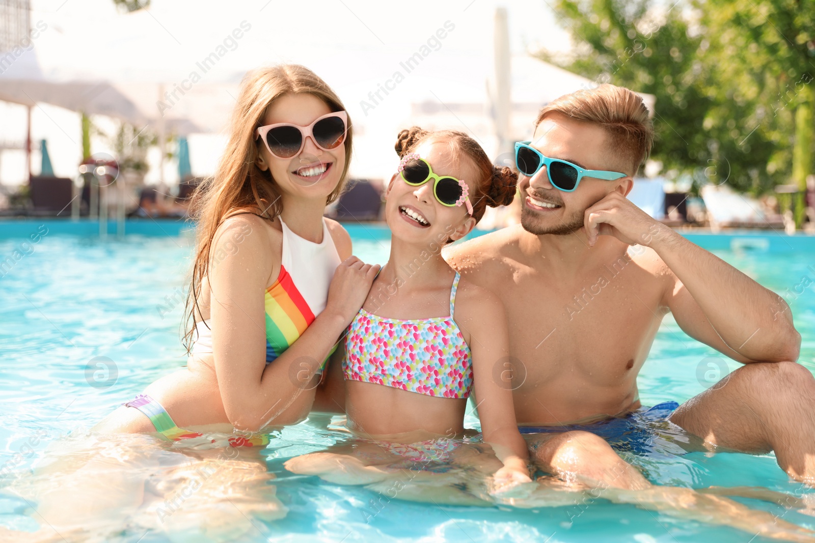 Photo of Happy family in pool on sunny day