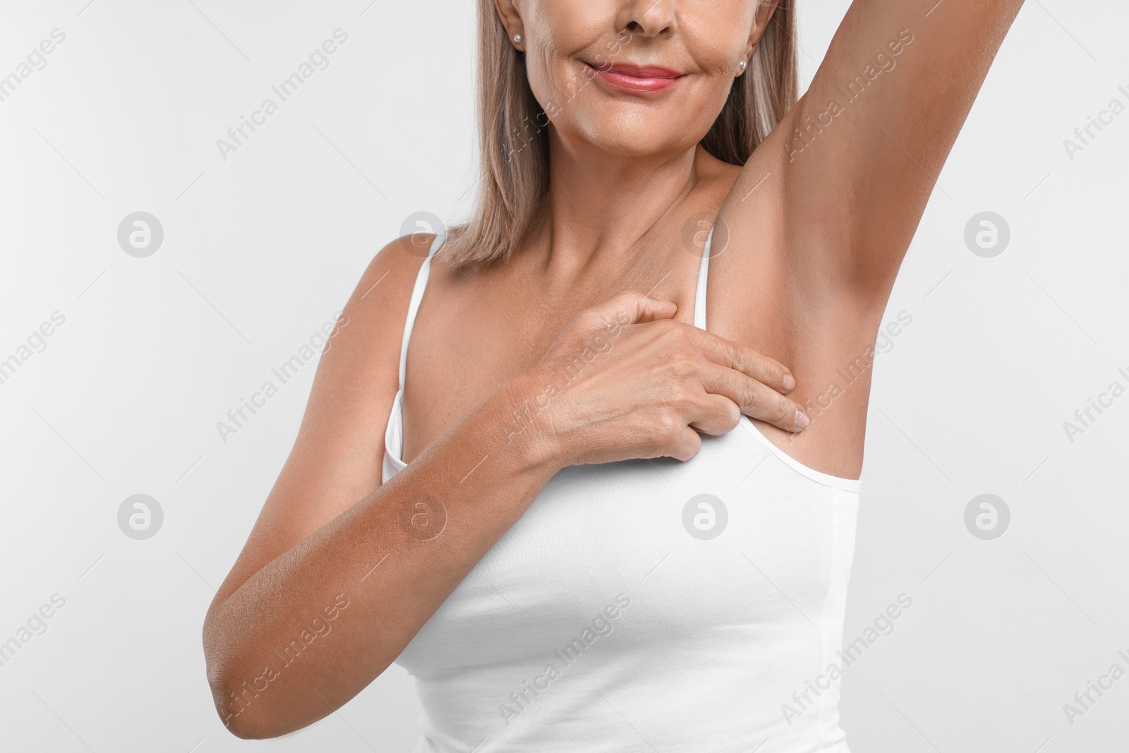 Photo of Woman doing breast self-examination on white background, closeup