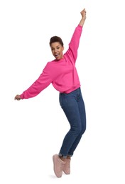 Happy young woman dancing on white background