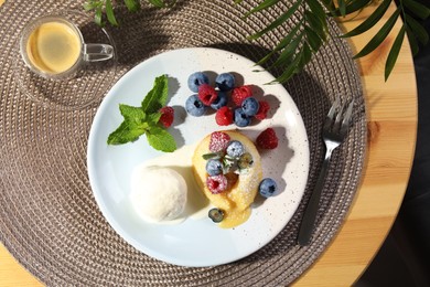 Photo of Delicious vanilla fondant served with ice cream and berries on table, flat lay