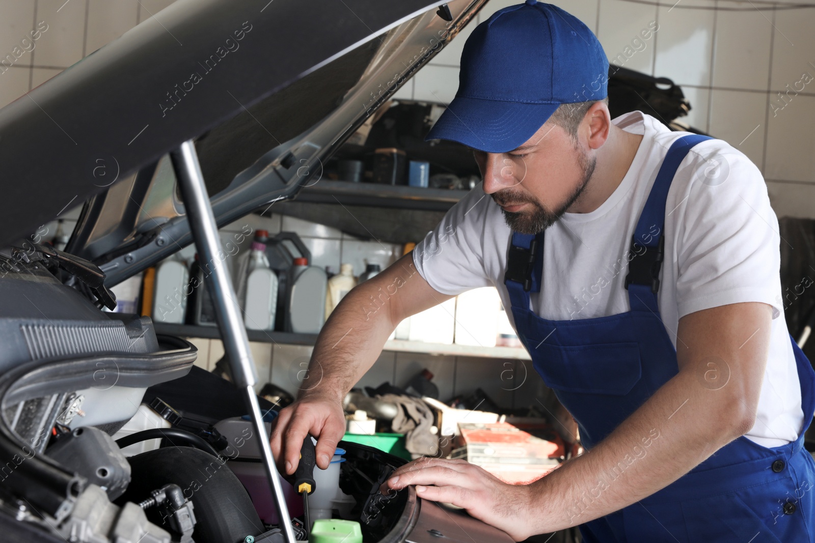 Photo of Professional auto mechanic fixing modern car in service center