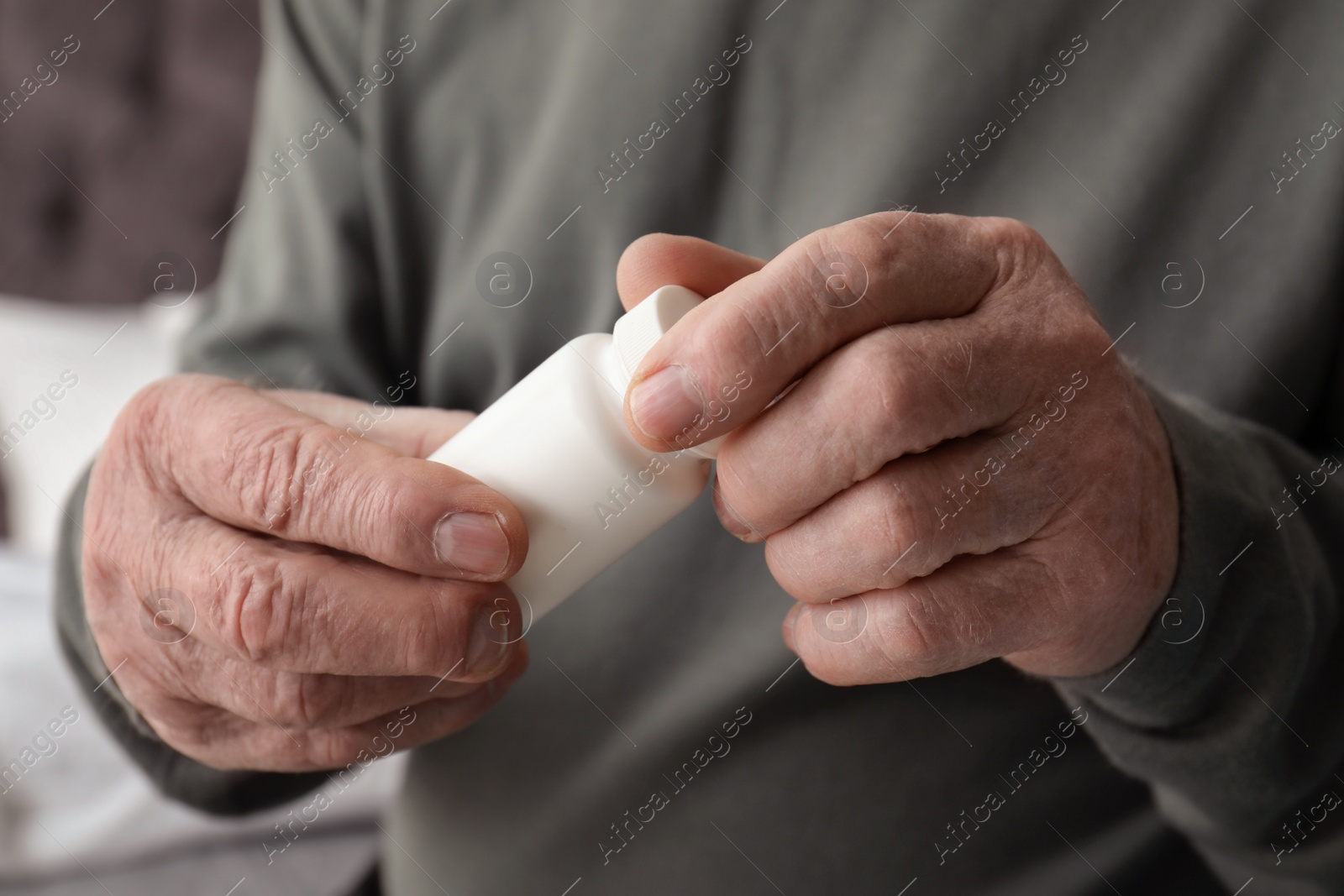 Photo of Senior man holding bottle with pills in his hands, closeup