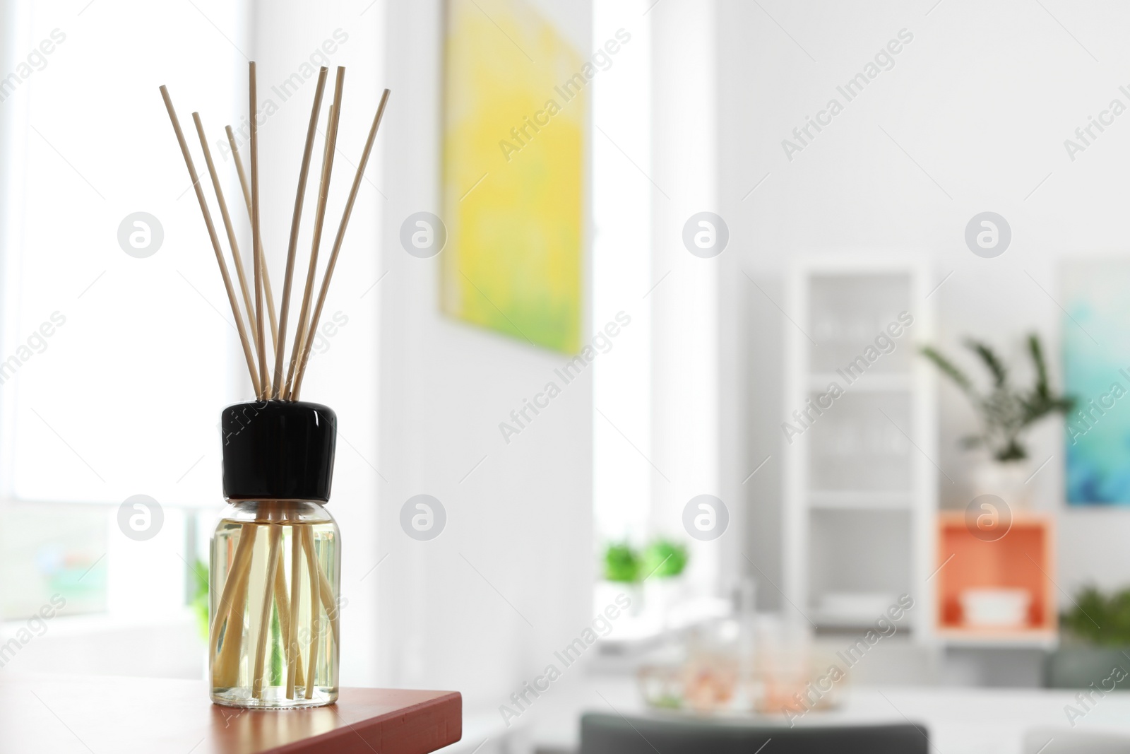 Photo of Aromatic reed air freshener on table in room