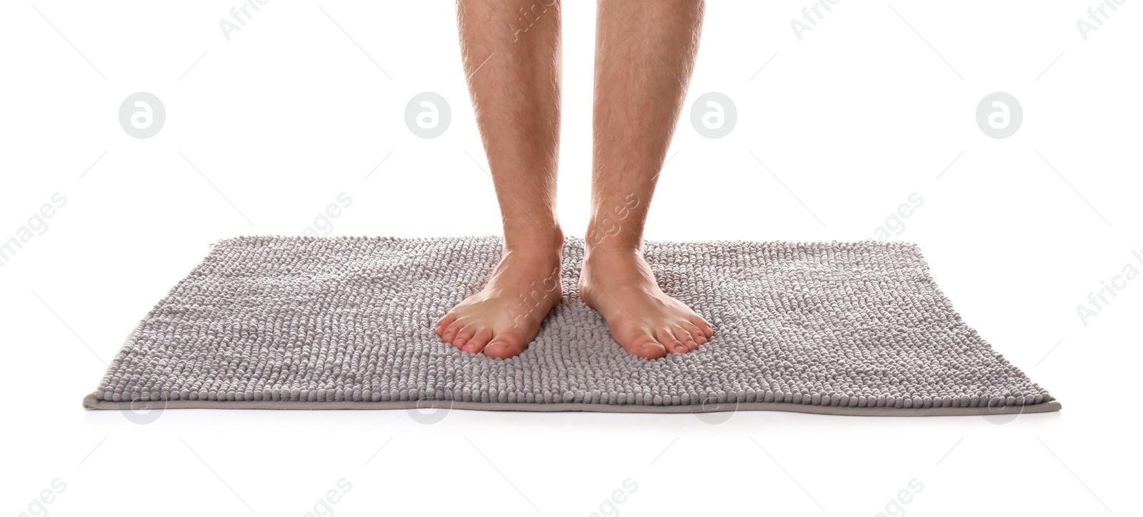 Photo of Man standing on soft grey bath mat against white background, closeup