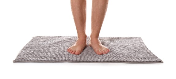 Man standing on soft grey bath mat against white background, closeup