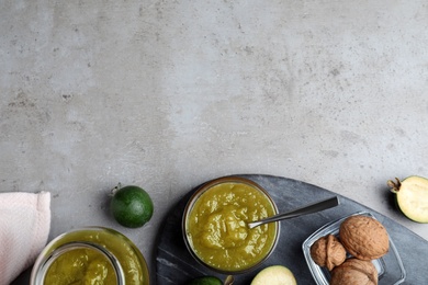 Photo of Feijoa jam and fresh fruits on grey table, flat lay. Space for text