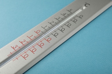 Photo of Weather thermometer on light blue background, closeup