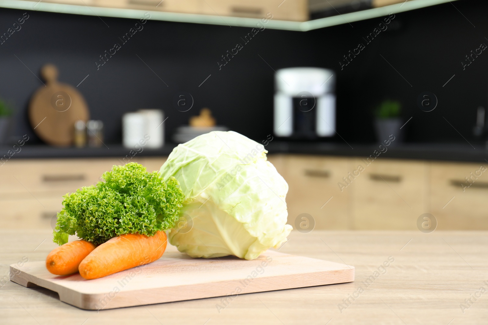 Photo of Fresh vegetables on wooden table in kitchen. Space for text