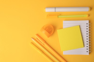 Photo of Flat lay composition with notebook and different school stationery on yellow background, space for text. Back to school