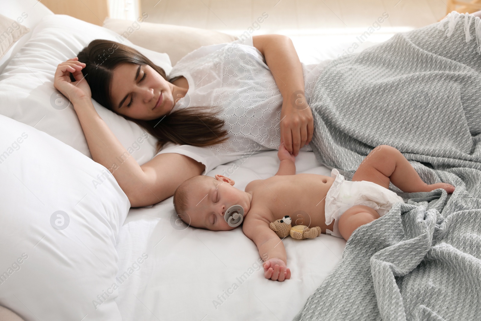 Photo of Mother with her cute baby sleeping in bed