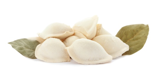 Raw dumplings with bay leaves on white background