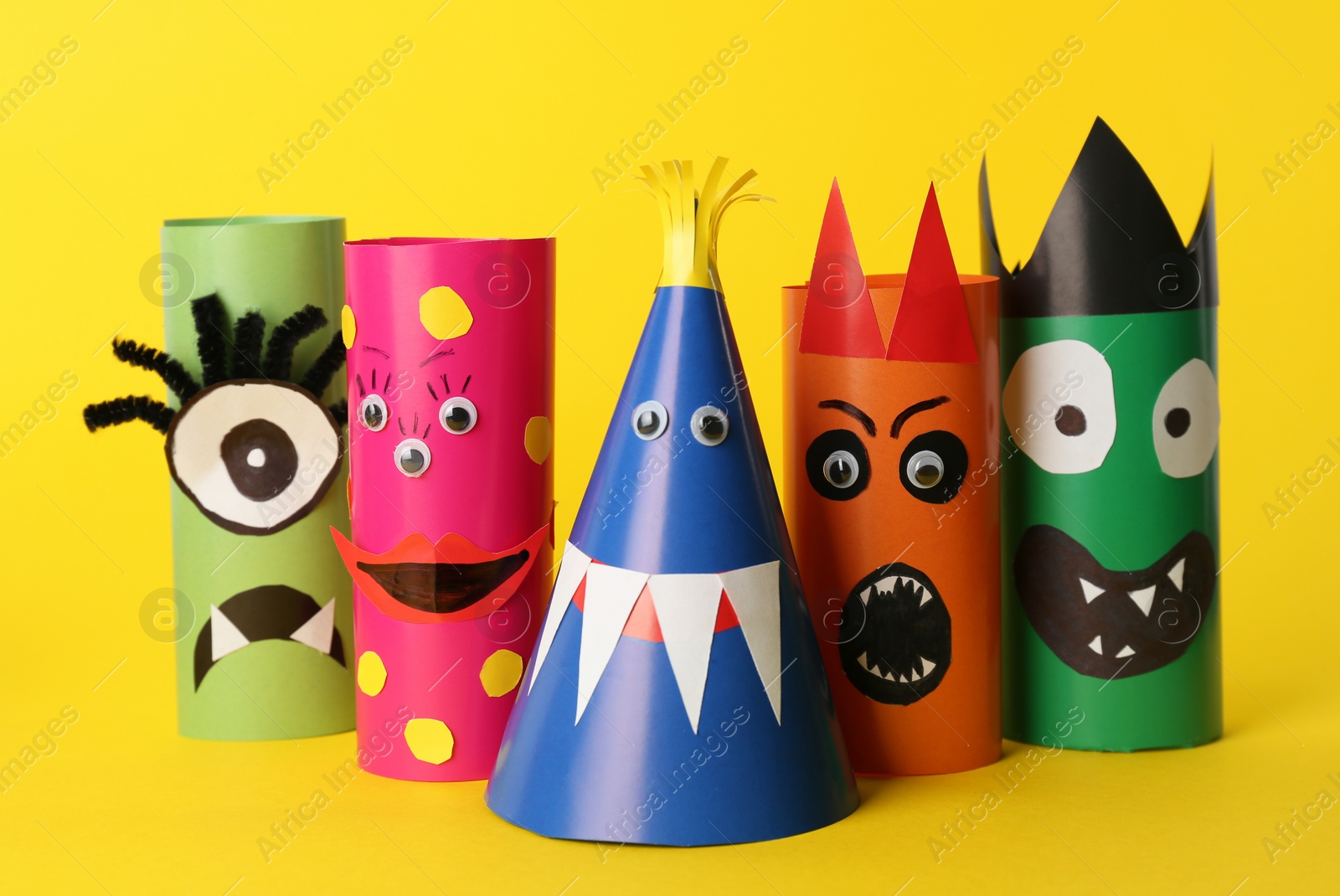 Photo of Funny monsters on yellow background. Halloween decoration