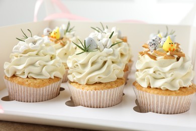 Tasty Easter cupcakes with vanilla cream in box, closeup