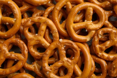 Photo of Many delicious pretzel crackers as background, closeup view