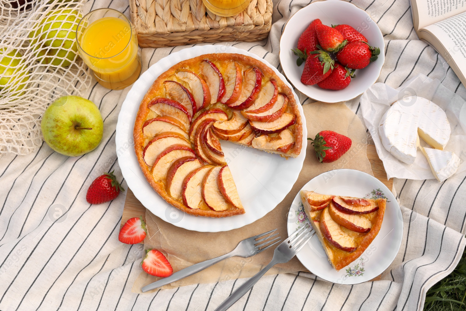 Photo of Blanket with different products outdoors, top view. Summer picnic