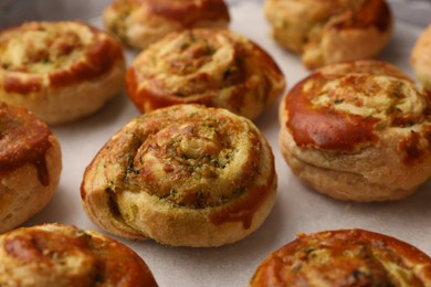 Fresh delicious puff pastry with tasty filling on parchment, closeup